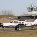 Flugplatz+Bad+Neustadt+-+Grasberg+am+27.2.2022%2C+Piper+28+RG+rollt+am+Clubheim+vorbei